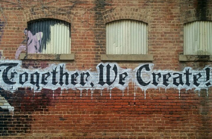 Graffiti on a wall saying 'together we create'